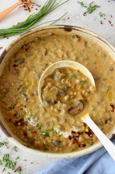 a wooden spoon in a bowl filled with mushroom soup