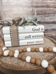 stack of books with white and brown beads tied to each other on top of them