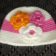 there is a crocheted hat with flowers on it