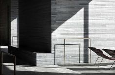 two chairs sitting next to each other in front of a wall with long shadows on it