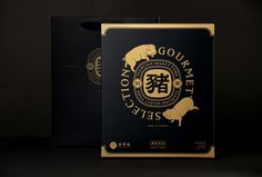 two black boxes with gold foil designs on the front and back, each containing a pig logo