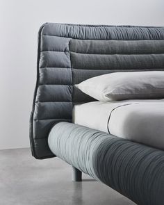 an upholstered bed with pillows on it