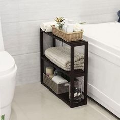 a white bath tub sitting next to a wooden shelf filled with towels and other items