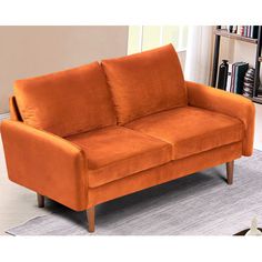 an orange couch sitting on top of a rug