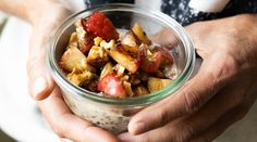 a person holding a glass jar filled with food