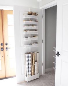 an open door with shelves and baskets on the floor in front of it, next to a pair of doors