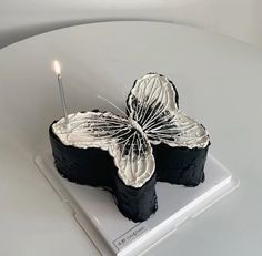 a piece of cake with a lit candle on it sitting on top of a plate