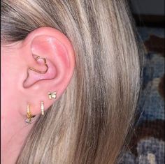 a close up of a person's ear with two different piercings on it