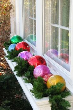 christmas ornaments are lined up on the window sill