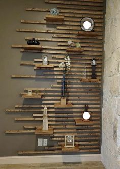 a wall made out of wooden pallets with lights on each side and vases in the middle