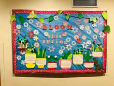 a bulletin board with flowers and plants on it that says bloom this spring in front of a classroom door