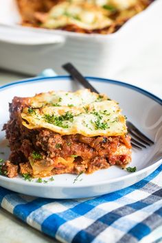 a white plate topped with lasagna covered in cheese