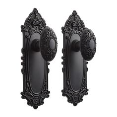 two black door knobs with ornate designs on the front and back of each one