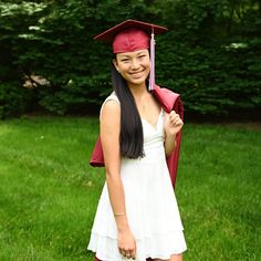 a woman in a graduation cap and gown posing for a photo with her graduate's tassel