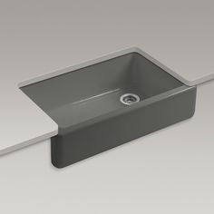 a gray sink sitting on top of a white counter