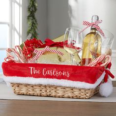 a basket filled with wine, champagne and candy canes on top of a table