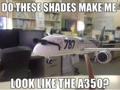 a model airplane sitting on top of a desk in front of a bookcase with the words do these shades make me look like the a 350?