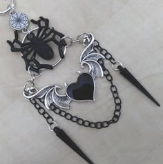 Rearview mirror charm made with a spider web connector charm, a black spider, a heart with wings and horns, and 2 black spike charms, as shown in the pictures. Measures about 5 inches from the rearview down. Includes the chain to hook onto the rearview mirror. Very unique and beautiful goth accessory! Black Heart-shaped Jewelry For Alternative Fashion, Black Heart Jewelry For Alternative Fashion, Heart-shaped Jewelry For Halloween Alternative Fashion, Black Gothic Charm Jewelry, Black Gothic Jewelry With Charms, Heart With Horns, Gothic Car, Rearview Mirror Charm, Wings Black