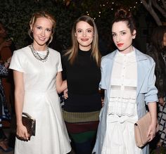 three women standing next to each other at an event