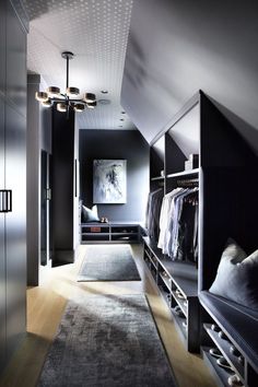 a walk - in closet with lots of clothes hanging on the walls and shelves next to it