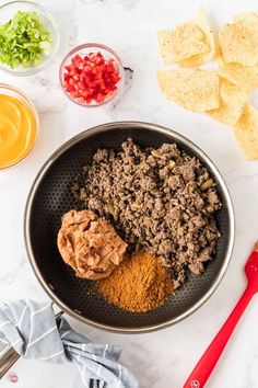 the ingredients to make this taco salad are in a bowl, including tortilla chips and guacamole