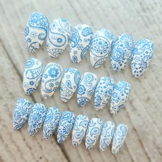 several blue and white decorated eggs sitting on top of a wooden table next to each other