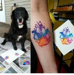 a dog is sitting on the floor and next to a tattoo that has watercolor splashes on it