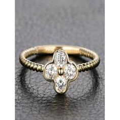 a yellow gold ring with three diamonds on the front and center, sitting on a black surface