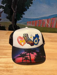 Show your California pride and score style points with The California Love Trucker Hat! Hand-crafted in our Laguna Beach storefront, this black and white trucker hat features an assortment of patches. Rock it at the beach or on the streets for a unique and playful look. Adult size, a Cactus Jane original White Trucker Hat For Festivals, One Size Fits Most, White Trucker Hat For Festival, White One Size Trucker Hat For Festivals, Multicolor 5-panel Trucker Hat For Summer, Fun Summer Snapback Hat With Patches, Summer Adjustable Snapback Hat With Patches, Adjustable Summer Snapback Hat With Patches, Multicolor Trucker Hat For Summer Streetwear, White Snapback Trucker Hat For Festivals