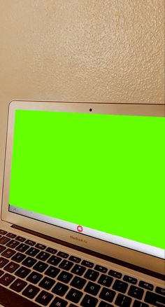 an open laptop computer with a green screen