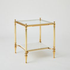 The Medford Tables feature a two-tiered design with luxurious white marble and tempered glass in a polished brass frame  perfect for both entertainment and storage. Dimensions Overall 20"L x 20"W x 22.75"H (56 lbs)  Finish Shiny Brass Shiny Brass Clean glass with professional glass cleaner; Dust with a soft, dry cloth Glass is clear tempered 8 mm thick Gold Nightstand, Glass Side Table, Small Nightstand, Brass Side Table, Glass Side Tables, New Condo, Global Views, Brass Table, Glass Cleaner