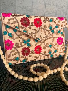 "This a beautiful handmade versatile purse with a magnetic closure from India. It can be worn over the shoulder, across the body. The strap may be tucked inside to be worn as a clutch. The floral pattern spans both the front and back. It would make a lovely statement piece to accent any outfit.  Clutch Bags, Indian Wedding Gifts, Wedding favor, Gift Party Handbag, Indian Clutches, Gift for Her, Gift for Mom. 9.5\" Length x  29.5\" Height (from Bottom to top of handle) x 6.5\" Width Thank you for visiting BONNET VINTAGE!  Please check out my other listings for more great finds!  https://www.etsy.com/shop/BonnetVintage Please like and share our page. Thank you." Rectangular Shoulder Bag With Magnetic Closure As Gift, Elegant Shoulder Bag With Multicolor Embroidery, Gift Clutch Shoulder Bag With Magnetic Closure, Pink Rectangular Shoulder Bag For Festive Occasions, Festive Rectangular Bag With Floral Embroidery, Traditional Floral Embroidered Clutch For Everyday, Traditional Floral Embroidery Clutch For Everyday, Festive Pink Rectangular Shoulder Bag, Envelope-shaped Box Bag As A Gift