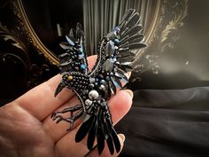 black raven brooch is 100% handmade. A lot of people are looking for something new nowadays. It's important for everyone to be special and have something exclusive. But there are over 7 billion people on the planet, so where to find such things? Well, how many individuals have a Crow brooch made by a talented master? A glass beaded black brooch raven will add charm to your outfit, making it shinier and more chic. It's great for both everyday and dinner or party looks. This bird brooch may become a symbol of sorts, representing a certain trait or habit you want to instill. Besides, such a rhinestone bird can become an amazing gift for hummingbird lovers! This handmade embroidered bird will melt any heart and enchant the person with its shine. Bird jewelry should become a worldwide trend! To Black Fantasy Costume Jewelry, Fantasy Black Costume Jewelry, Black Fantasy Jewelry For Costume, Black Gothic Brooch, Black Gothic Jewelry Brooch, Black Gothic Brooch Jewelry, 7 Billion People, Raven Jewelry, Beaded Bird