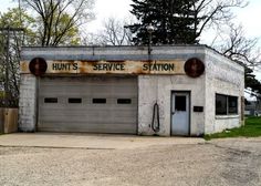 an old run down service station with two garage doors