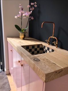 a sink and counter in a room with flowers on the counter top next to it