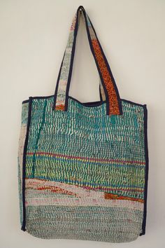 a multicolored tote bag hanging on a wall