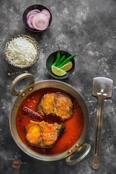 an overhead view of some food in a pot with spoons and utensils