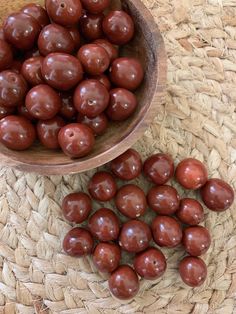 a bowl filled with chocolate covered apples next to another bowl full of chocolate coated apples