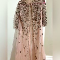 This Vintage Pink Duster Exudes Elegance And Charm With Its Soft, Rosy Hue And Flowing Silhouette. Intricate Hand-Embroidered Beading And Appliqus Adorn The Fabric, Adding A Vibrant Contrast And Delicate Texture. The Embroidery Features Floral Motifs And Geometric Patterns, Giving The Piece A Unique, Artisanal Touch. Perfect For Layering Over A Dress Or Casual Outfit, This Duster Combines Retro Style With A Timeless Flair. The Craftsmanship And Attention To Detail Make It A Standout Statement Pi Floral Motifs, Geometric Patterns, Floral Motif, Casual Outfit, Vintage Pink, Retro Style, One Size Fits All, Hand Embroidered, Retro Fashion