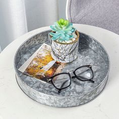 a pair of glasses sitting on top of a tray next to a potted plant