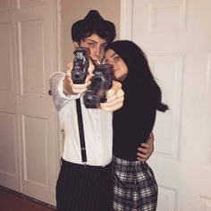 a man and woman taking a selfie in front of a door with a camera