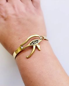 Brass gold plated semi-cuff with side closure. Diameter is 2.2 inches, width is .25 inches. Very lightweight. Egyptian god Eye of Horus design. Made in Egypt. Adjustable Symbolic Gold Cuff Bracelet, Gold Symbolic Bangle Cuff Bracelet, Symbolic Gold Bangle Cuff Bracelet, Gold-tone Cuff Bracelet As Gift, Gold-tone Cuff Bracelet Gift, Adjustable Gold-tone Metal Cuff Bracelet, Horus Design, God Eye, Egyptian God