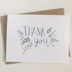 a card with the words thank you written in black ink on top of white paper