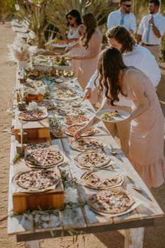 a long table filled with pizzas on top of it