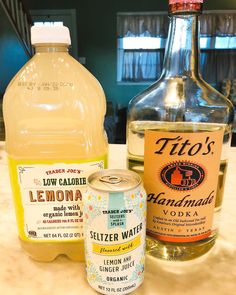 two bottles of lemonade and a can of soda sit on a counter top next to each other