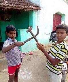 two young boys are holding an old hammer