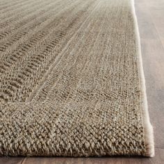 an area rug on the floor with wooden floors and wood planks in the background