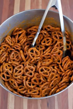 a large metal pan filled with pretzels on top of a wooden table