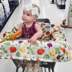 a baby sitting in a shopping cart at the grocery store