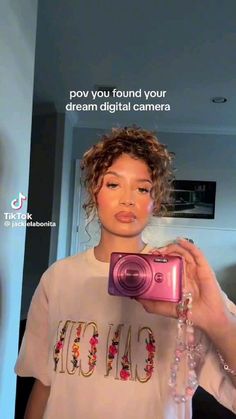 a woman holding up a pink camera in front of her face with the caption, you found your dream digital camera